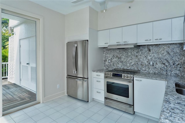 kitchen with light tile patterned flooring, ceiling fan, light stone countertops, white cabinetry, and appliances with stainless steel finishes