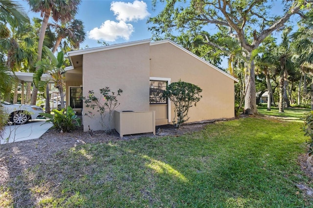 5071 Village Gardens Dr Unit 5, Sarasota, FL 34234 - view of property exterior with stucco siding and a lawn