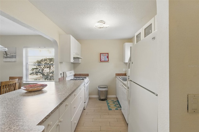 5071 Village Gardens Dr Unit 5, Sarasota, FL 34234 - kitchen featuring white appliances, white cabinets, a textured ceiling, light countertops, and under cabinet range hood