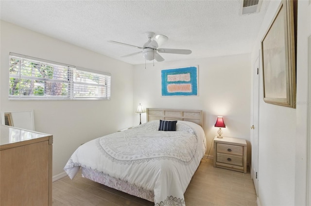 5071 Village Gardens Dr Unit 5, Sarasota, FL 34234 - bedroom with light wood finished floors, a textured ceiling, and ceiling fan