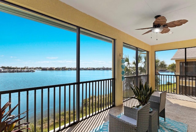 sunroom / solarium featuring a water view and ceiling fan