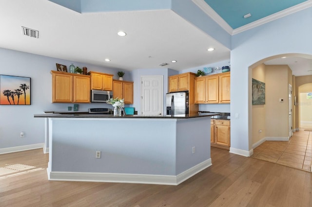 kitchen featuring an island with sink, appliances with stainless steel finishes, crown molding, and light hardwood / wood-style floors