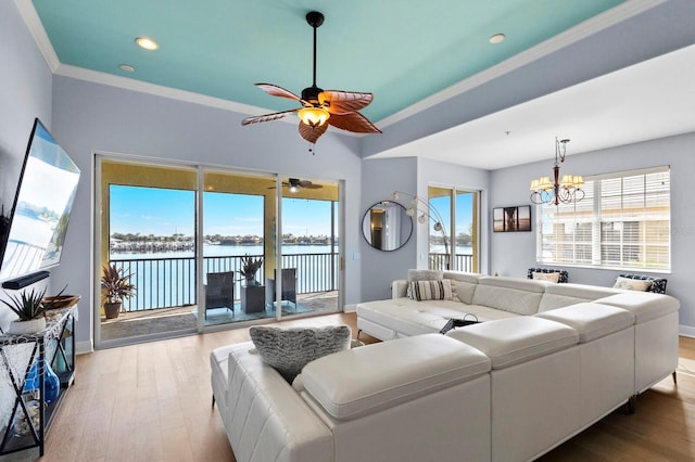 living room with ornamental molding, a water view, plenty of natural light, and hardwood / wood-style floors