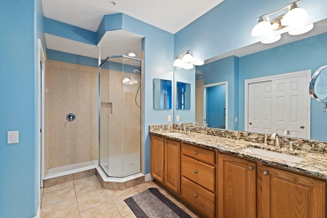 bathroom featuring tile patterned floors, a shower with shower door, and vanity