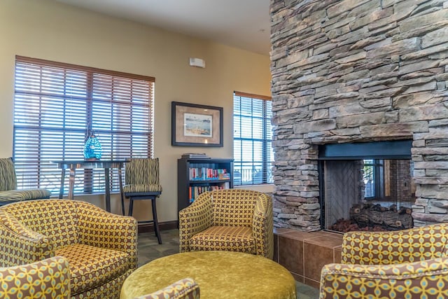 living room with plenty of natural light and a stone fireplace