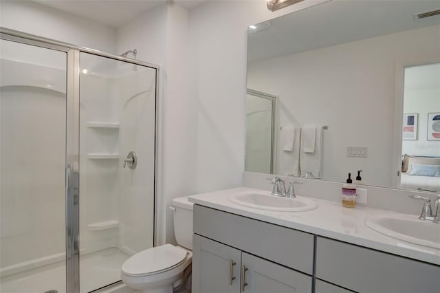 bathroom featuring walk in shower, vanity, and toilet