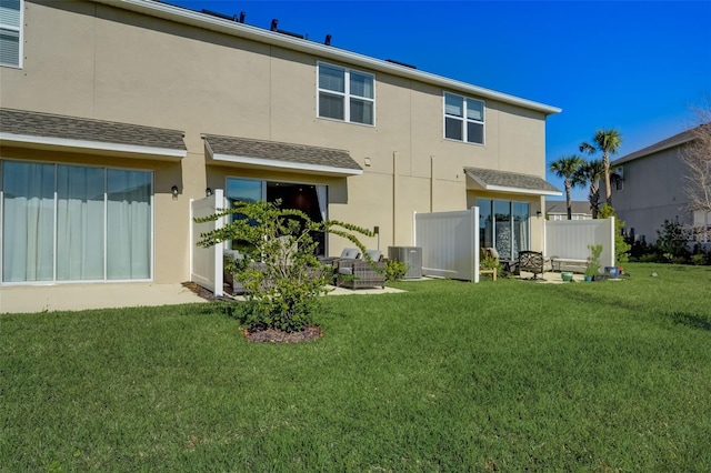 back of property with a lawn and central air condition unit