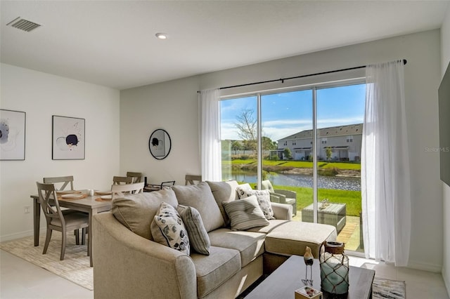 living room with a water view and light tile patterned floors