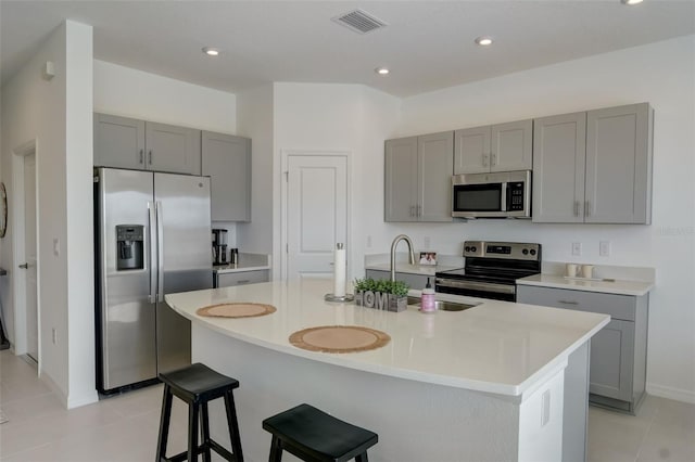 kitchen featuring a breakfast bar area, a kitchen island with sink, appliances with stainless steel finishes, and sink