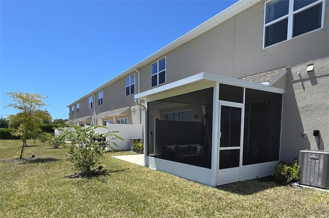 back of house with a lawn, cooling unit, and a sunroom