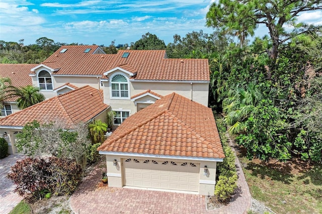 view of front of home with stucco siding, driveway, and a tiled roof