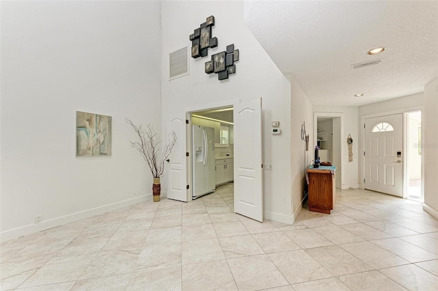 tiled entryway featuring a textured ceiling