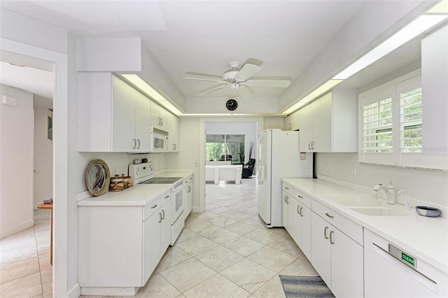 kitchen with sink, white cabinets, and white appliances