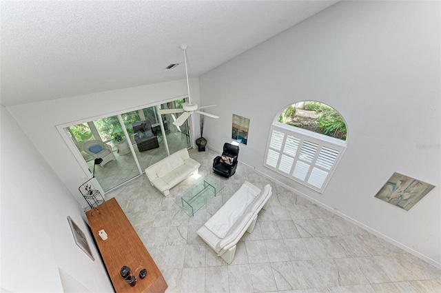 living room featuring a textured ceiling, high vaulted ceiling, and ceiling fan