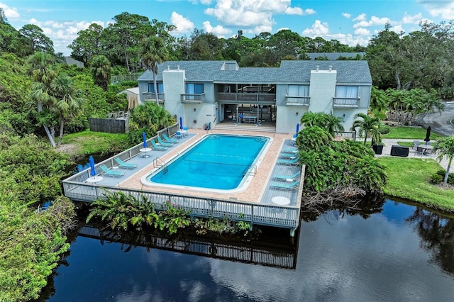 view of swimming pool featuring a water view and a patio