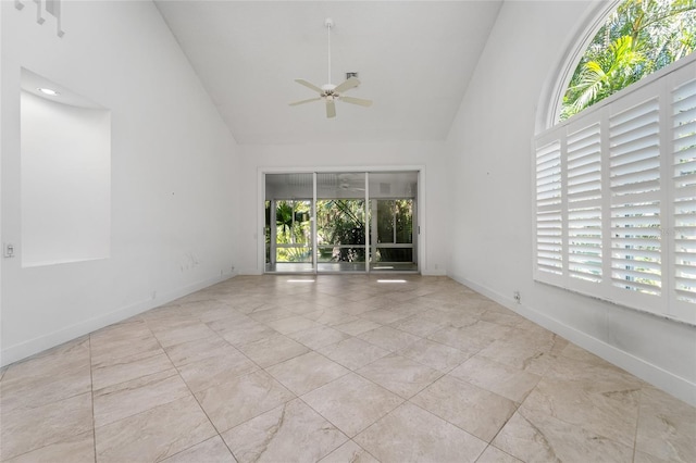 unfurnished room featuring baseboards, high vaulted ceiling, and a ceiling fan