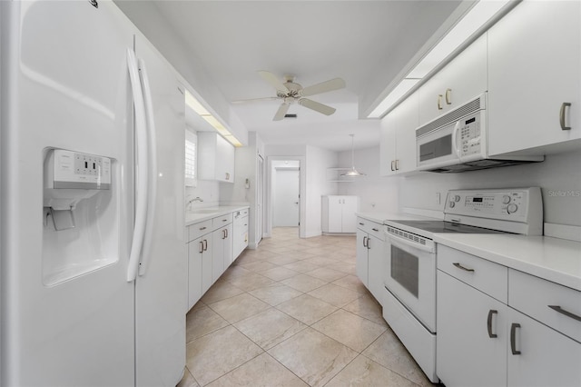 kitchen with white appliances, white cabinetry, light countertops, and a ceiling fan