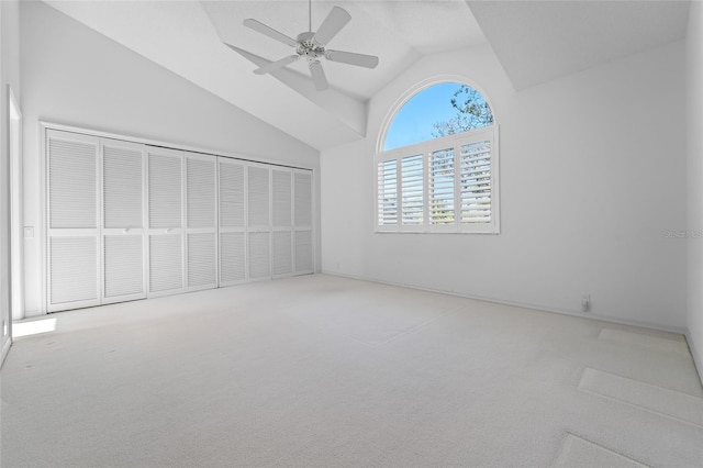interior space featuring high vaulted ceiling, ceiling fan, a closet, and carpet floors