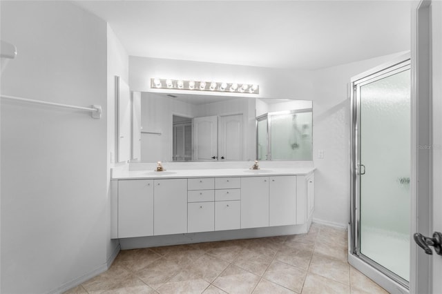 bathroom with double vanity, a sink, and a stall shower
