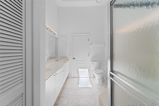 full bath featuring double vanity, toilet, tile patterned flooring, and a sink