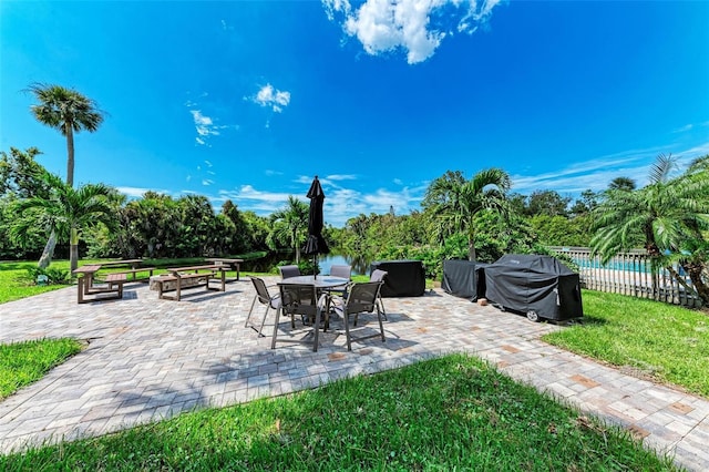 view of patio / terrace featuring a swimming pool, fence, outdoor dining space, and grilling area