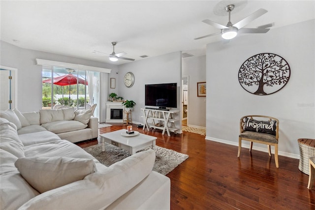 living room with ceiling fan and dark wood-type flooring