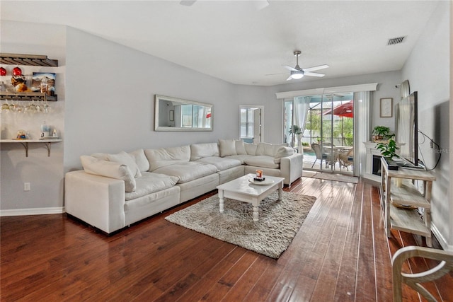 living room featuring dark hardwood / wood-style flooring and ceiling fan