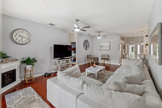 living room featuring ceiling fan and dark hardwood / wood-style floors