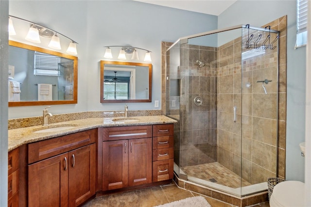 bathroom with tile patterned floors, a shower with door, vanity, and toilet