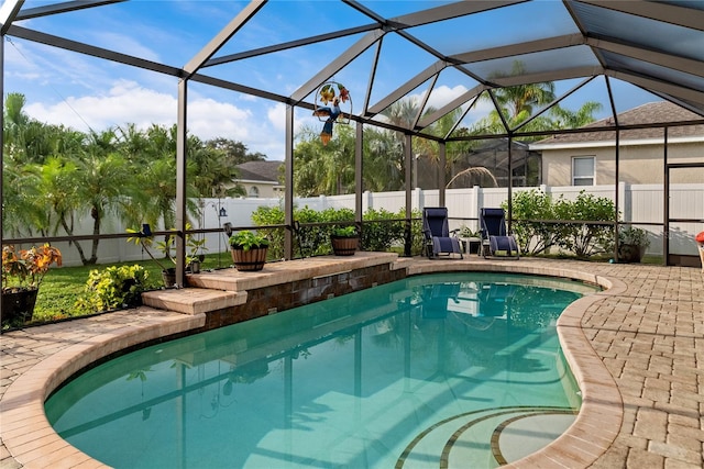 view of swimming pool featuring glass enclosure and a patio area