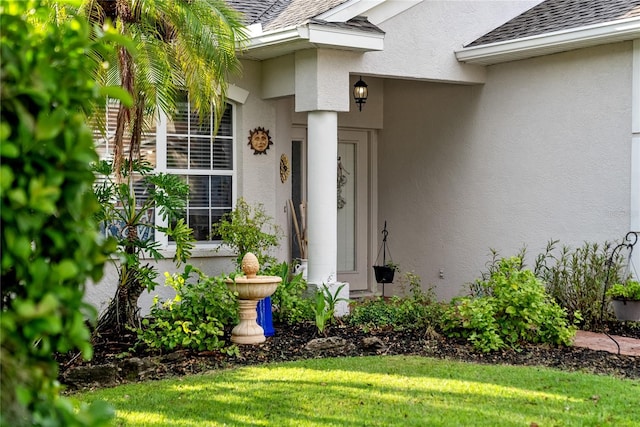 view of exterior entry featuring a yard