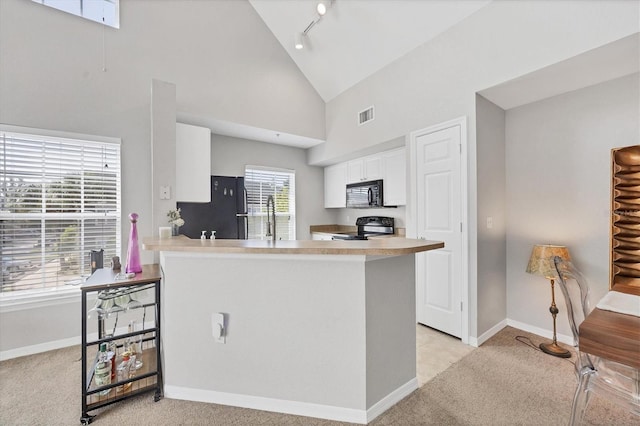 kitchen with high vaulted ceiling, white cabinets, kitchen peninsula, a breakfast bar area, and black appliances