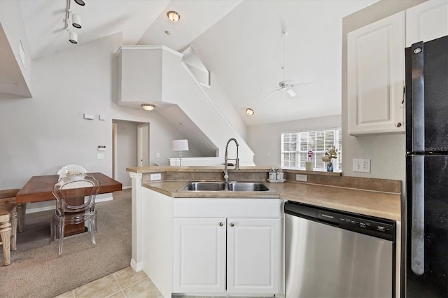 kitchen with dishwasher, light tile patterned flooring, sink, white cabinetry, and black refrigerator