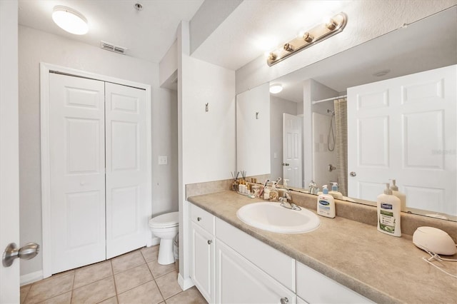 bathroom featuring tile patterned flooring, walk in shower, vanity, and toilet