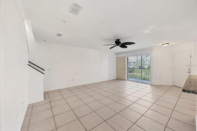 empty room with ceiling fan and light tile patterned floors