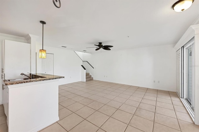 unfurnished living room featuring crown molding, light tile patterned floors, and ceiling fan