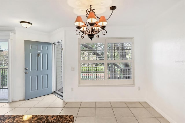 tiled entryway featuring ornamental molding, a notable chandelier, and plenty of natural light