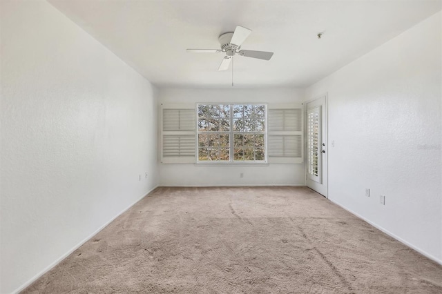 carpeted spare room featuring ceiling fan