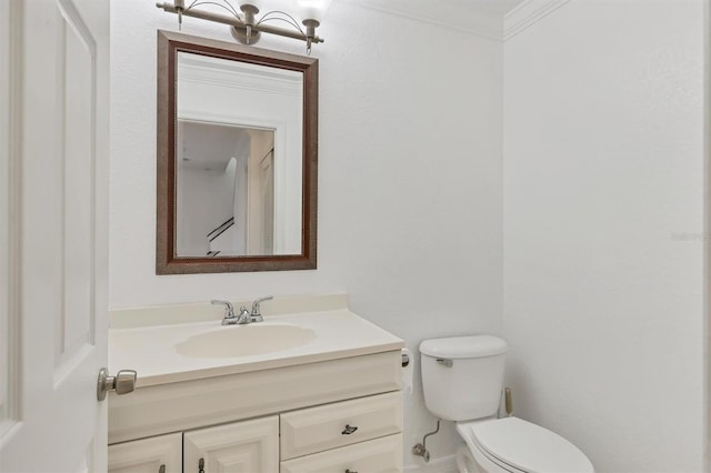 bathroom with toilet, crown molding, and vanity