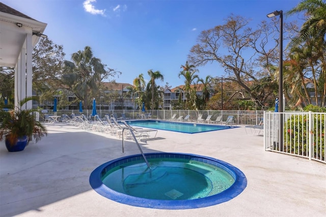 view of swimming pool with a hot tub and a patio area