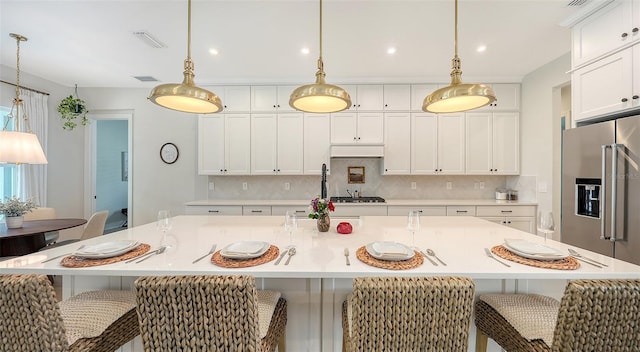 kitchen featuring a large island, pendant lighting, and white cabinets