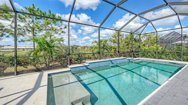 view of swimming pool featuring a patio area and a lanai