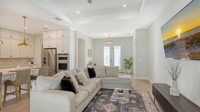 living room with french doors and light wood-type flooring