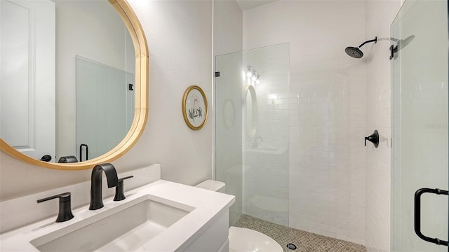 bathroom with a shower with door, vanity, and toilet