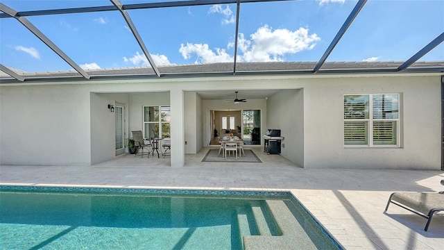 exterior space with a patio area, grilling area, glass enclosure, and ceiling fan