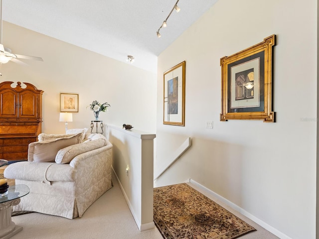 living area with lofted ceiling, ceiling fan, and light colored carpet