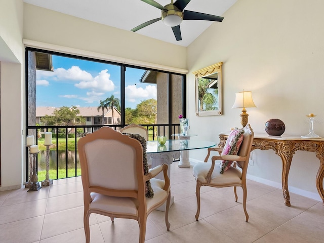 living area with vaulted ceiling, ceiling fan, and light tile patterned floors