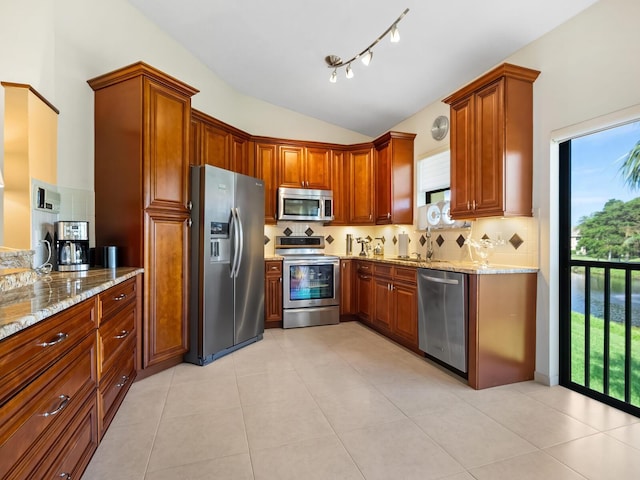 kitchen featuring decorative backsplash, appliances with stainless steel finishes, and light tile patterned floors