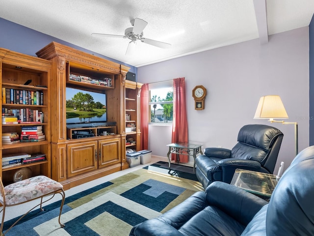 living room featuring ceiling fan, hardwood / wood-style flooring, and a textured ceiling