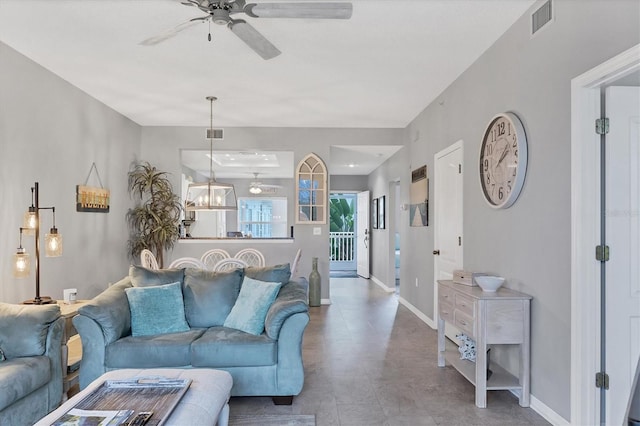 living room with ceiling fan with notable chandelier